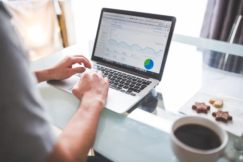 A laptop on a desk showing charts and analytics